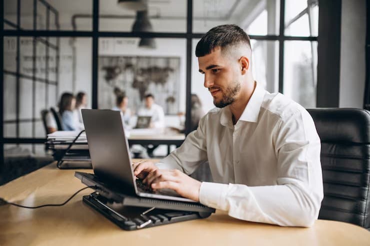 A professional working on a laptop in a modern office